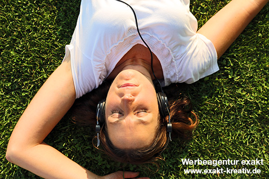 Frau hört im-Freien mit Kopfhörern Musik